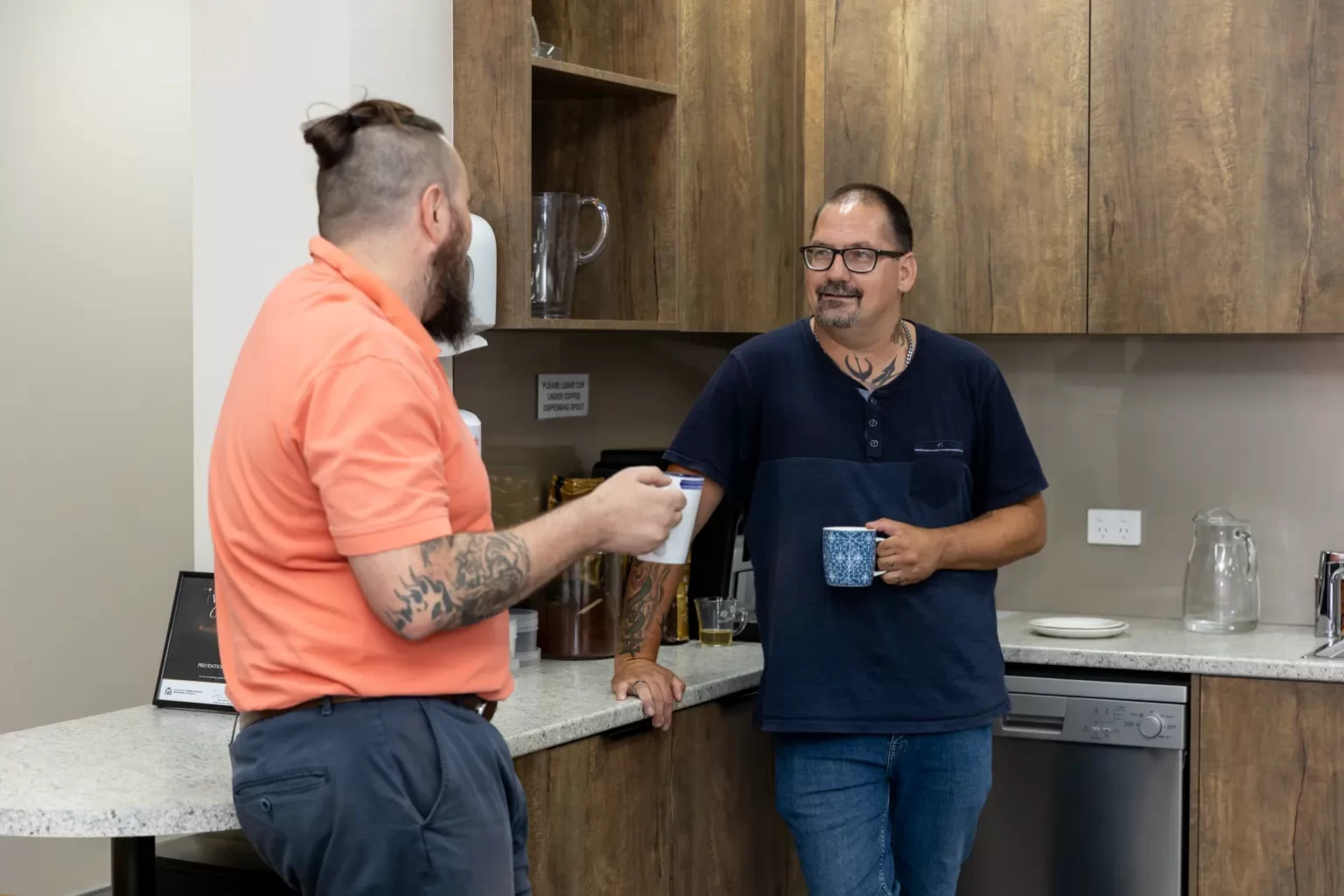 2 men communicating with cups in hands