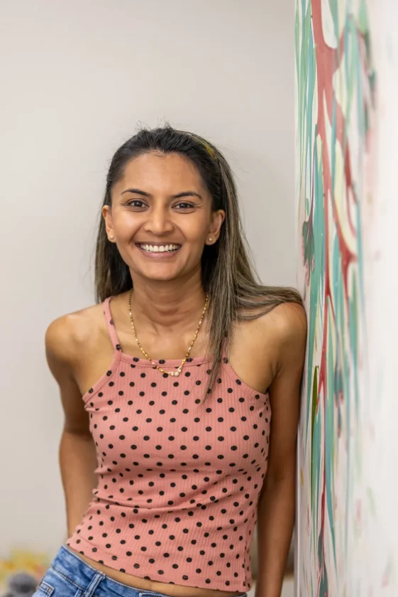 Young woman beside art mural