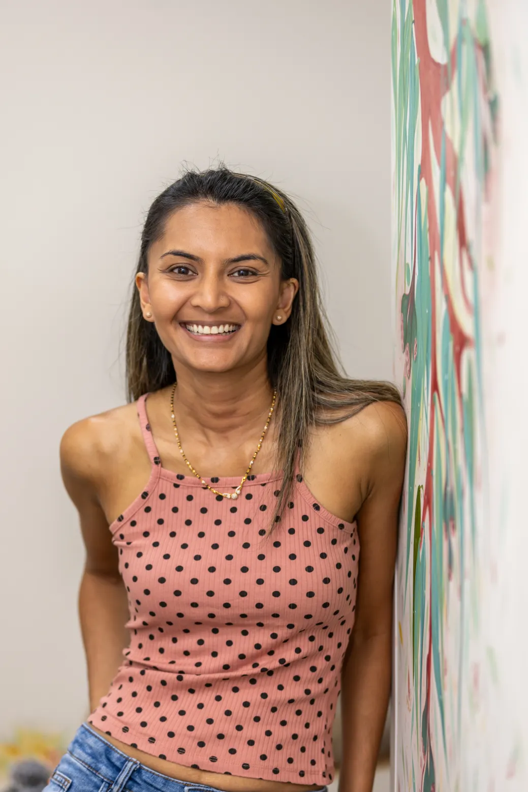 Young woman beside art mural