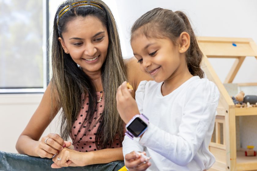 woman showing smart watch to child